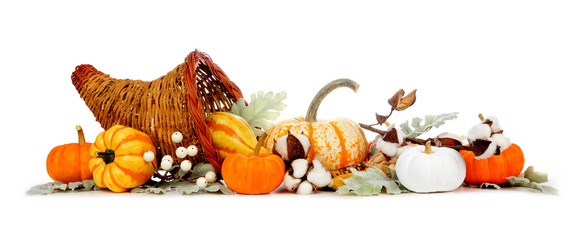 Thanksgiving cornucopia filled with autumn vegetables, pumpkins and fall decor isolated on a white...