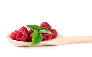 Raspberries in a wooden spoon on a white. Beautiful pink raspberries in a wooden spoon on a white background