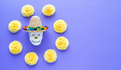 Skull with Mexican hat surrounded by yellow flowers of Dia de los Muertos. Day of the Dead. Copy...