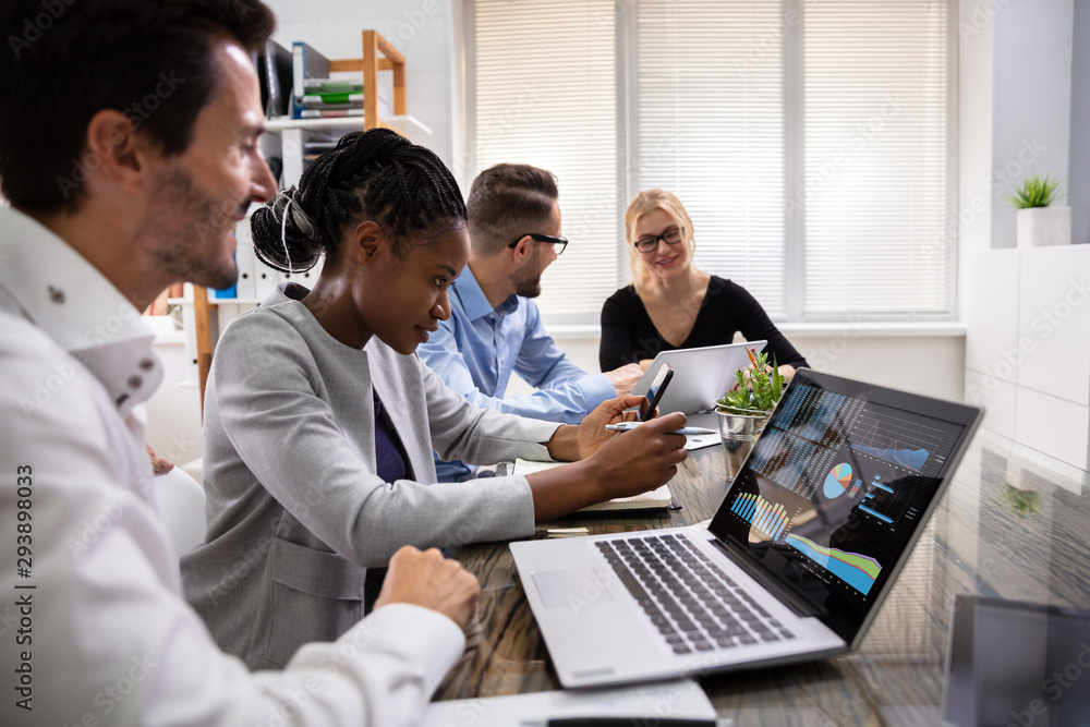 Poster group of businesspeople examining graph on computer