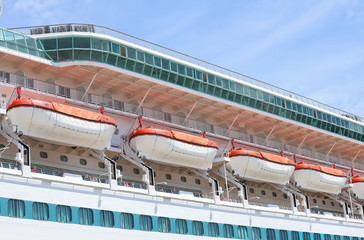 Close up of lifeboats lined up in a row on a luxury liner cruise ship.