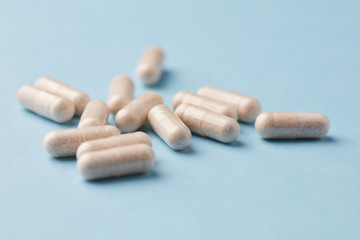 Ginkgo Biloba capsules. Dietary supplements. Bright paper background. Close up. Copy space. 