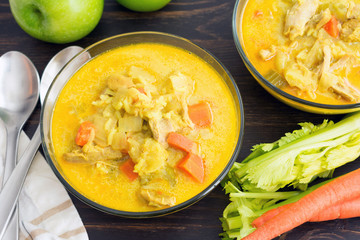 Bowls of curried chicken mulligatawny soup with apples, celery, and carrots