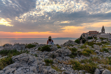The famoud Lubenice village at sunset over the sea in Cres island Croatia with a woman