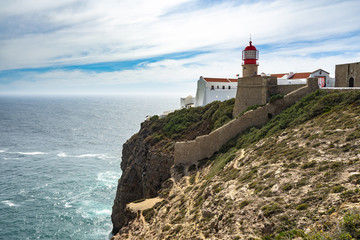 Fototapeta na wymiar The picturesque red lighthouse on the cliffs of Cabo de Sao Vicente(Cape St. Vincent) the .southwesternmost point of Portugal, Algarve