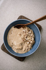 Flaxseed porridge in a blue bowl and wooden spoon