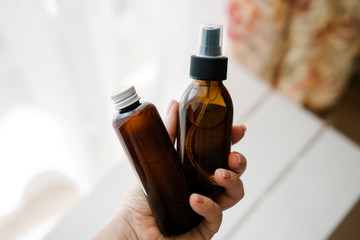 Two cosmetic bottles in woman's hands