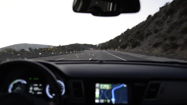 man's hand behind the wheel and views of the road