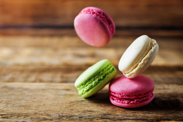 Multicoloured macarons on a dark wood background