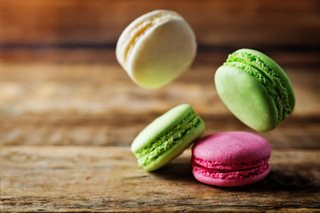Multicoloured macarons on a dark wood background