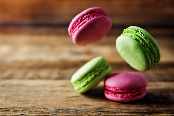Multicoloured macarons on a dark wood background