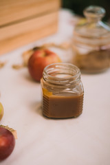 Homemade salty brown liquid caramel. Homemade soft caramel made from sugar on a background of apples and pumpkins