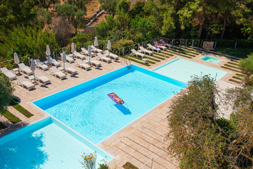 Young woman in bikini air mattress in the big swimming pool