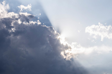 Fototapeta na wymiar white and grey clouds on a blue sky with a ray light