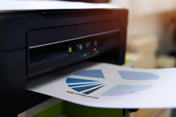 Printer printing document graph diagrams for report finacial business in office. Printer scanner...