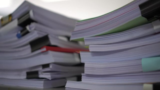 Piles unfinished documents reports files with overwork paper corner on teacher school desk office at university. Stack of messy paperworks assessment legal folder at workplace, tax audit concept
