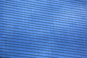 Window glass pattern background with reflected cloud and sky of office building.