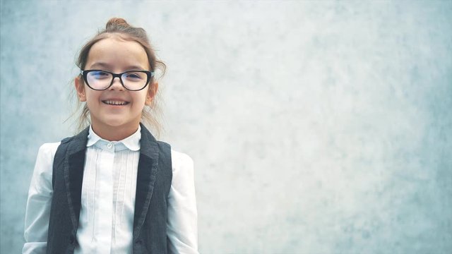 Close-up of a lady boss girl on a gray background. During this time, waving head goggles flew over to the nose. Look at the camera