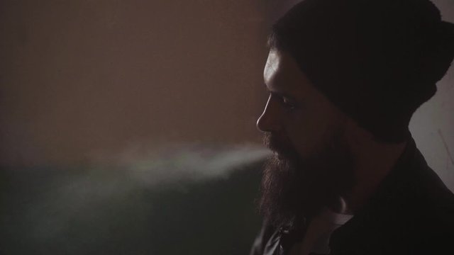 Night crime. Brutal man smoking at night time. Attractive guy outdoors at night. Being alone. Portrait super close up.