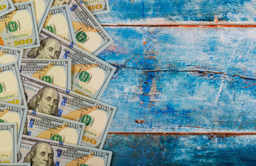 100 dollars banknotes bills on blue old wooden background Money concept.