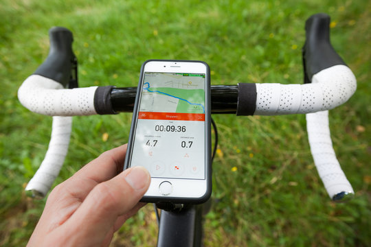 BATH, UK - SEPTEMBER 1, 2015 : Close-up of a smartphone mounted onto the handle bars of a road bike in a park. The phone is displaying the Strava app, which shows navigation and pace information.