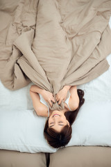 Smiling lying in her bed in bright bedroom