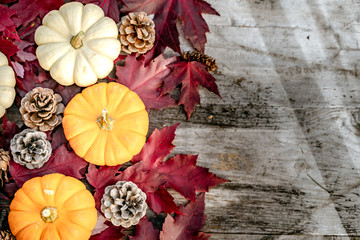 Pumpkins, dried leaves and pine wiht Autumn composition on wood background. Autumn, fall, halloween concept. Flat lay, top view, copy space
