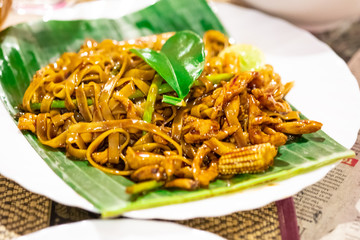 A plate of national Thai dish with Pad Ki Mao-Drunken Noodles closeup on the table.