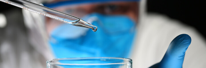 Male chemist look at test tube with yellow liquid biological research closeup. Conducts study urine...