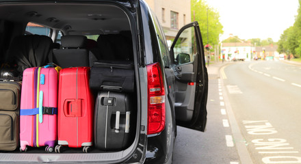 Closeup of back, rear side of black van car carrying  luggage, suitcases preparing for holiday with...