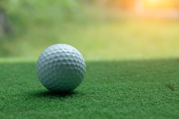 Blurred golf ball on green grass in the evening golf course