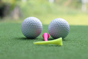 Golf ball and tee in beautiful golf course at sunset background.
