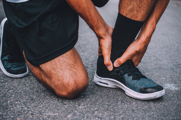 Runner injured in the foot while jogging space patella  sore on road, jogger hands joint leg...