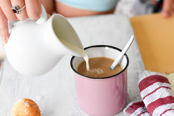 Coffee and milk on the table. Pouring milk into coffee/latte/ Breakfast table-starting a day
