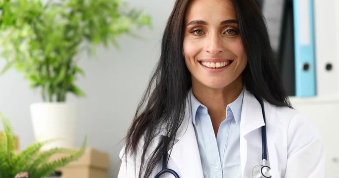 4k video smiling female doctor aganist hospital office background