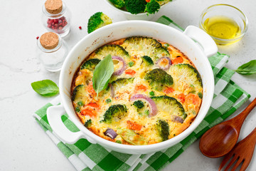 Frittata or casserole with broccoli and vegetables in baking dish. Vegetarian recipe.