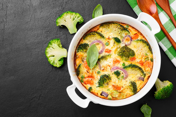 Frittata or casserole with broccoli and vegetables in baking dish. Vegetarian recipe.