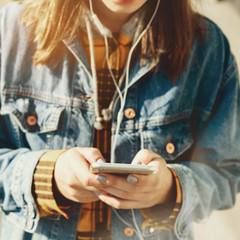 Young woman blogger browsing social networks on the street. Woman texting on her phone