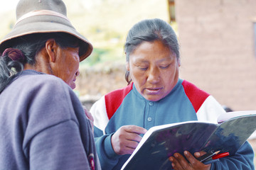 Two native american women holding a textbook. Education for adults.
