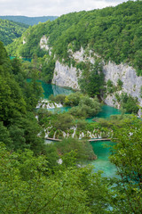 Fototapeta na wymiar Rushing pure fresh water cascades down the natural barriers into the turquoise colored Lake Kaluđerovac at the Plitvice Lakes National Park in Croatia