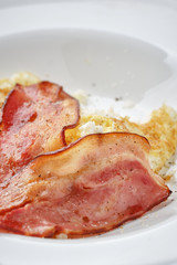 fried bacon and eggs on breakfast close up
