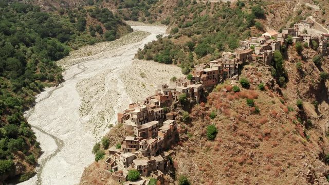 Roghudi Vecchio fascinating Italian ghost town located in Aspromonte mountains in Southern Italy. It was abandoned in 1973 after a series of natural disasters (flood). Travel destination. Aerial Shot.