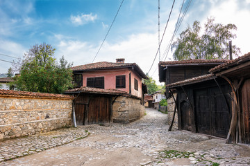 Fototapeta na wymiar Characteristic street with cobblestones and houses in the historic center of koprivshtitsa (Bulgaria)