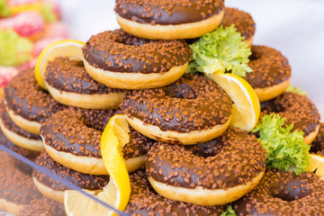 Assorted donuts with chocolate frosted, pink glazed and sprinkles donuts. 