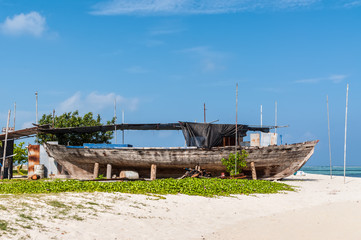 Fototapeta na wymiar An old wooden fishing boat on the coast of the Maafushi Island, Maldives. Paradise tropical island. Travel and tourism concept.