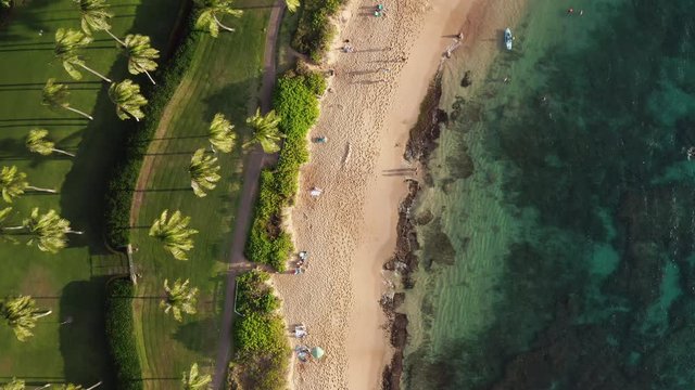 Top down aerial view of tropical white sand beach resort in Hawaii on sunny summer day