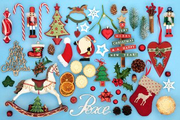 Christmas peace sign with retro tree bauble decorations, food, symbols and winter flora on blue background.