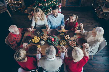 Top above and high angle view photo of large family having gathered to spend new year together grandchildren grandparents son and daughter wife husband hold each other hand praying senior mature young - Powered by Adobe