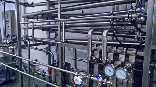 Milk factory production. Automated mechanized milking equipment closeup for farmland industry