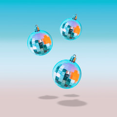 Flying in the air three Christmas balls with shadows on the pastel blue gradient background